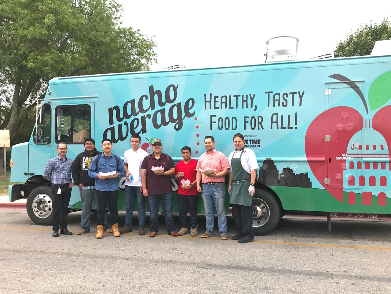 Group of high school students with food from the Nacho Average food truck