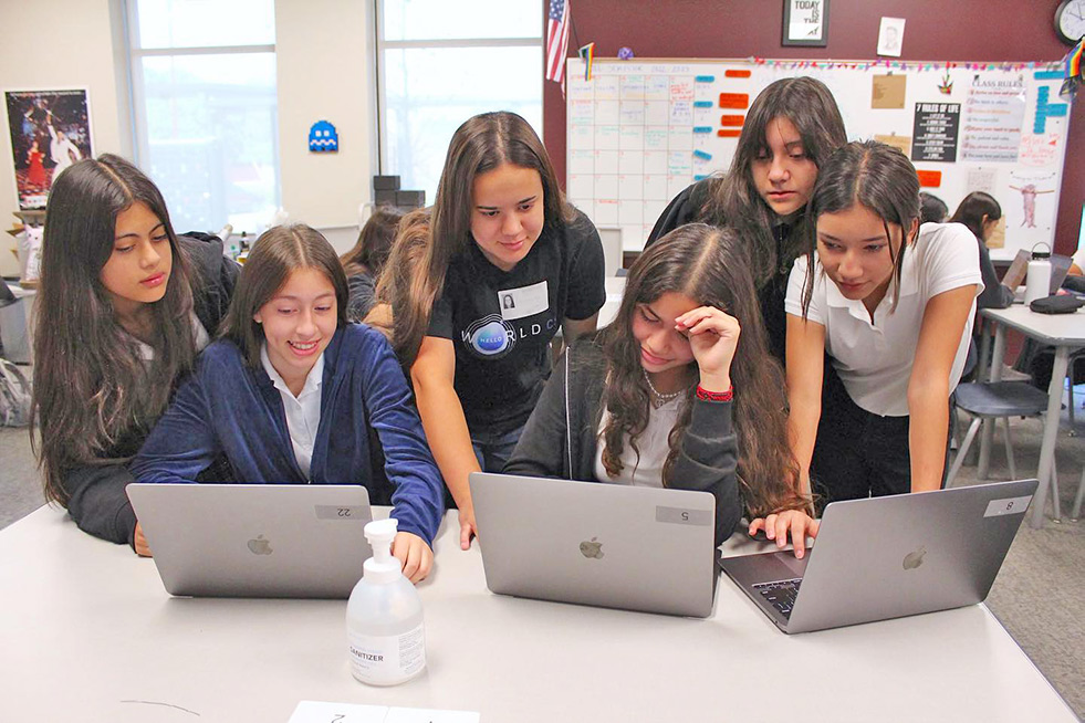 six high school students collaborating on three computers