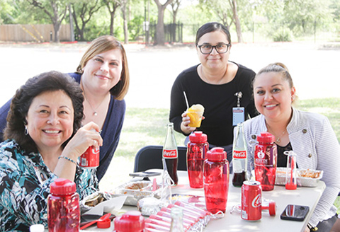 group of staff with reusable bottles and food utensils sitting at a table