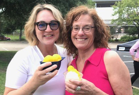Two female coworkers enjoy their mango Italian Icies