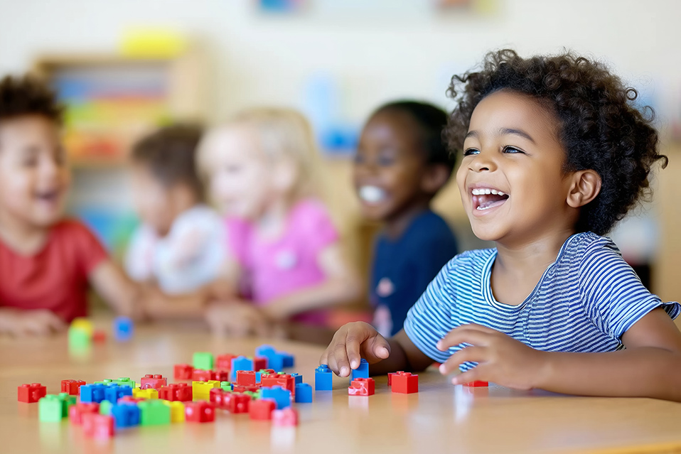 A group of young students playing with legos and laughing