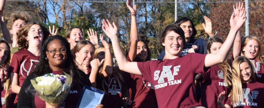 Austin High School head tennis coach Leslie Oduwole and her students celebrating her award.