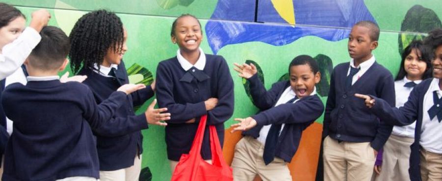 students celebrate their artwork being on city buses