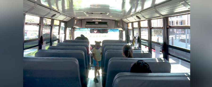 A student on a bus with a mask. 