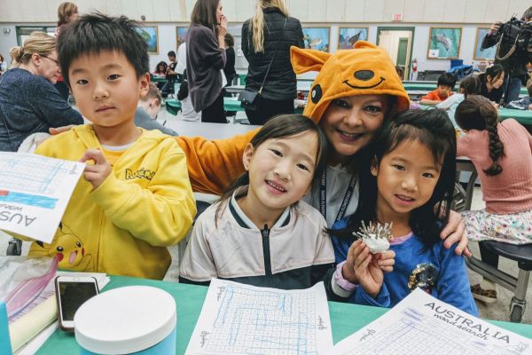 students holding their art