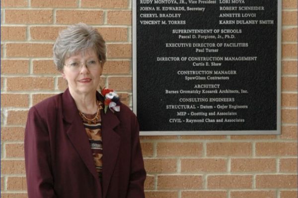 photo of a woman standing in front of a brick building.