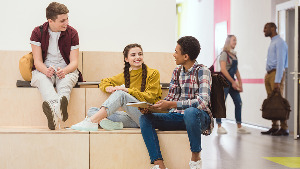 students collaborating together and student talking to teacher